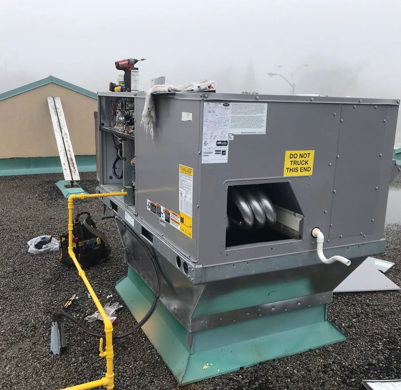 Commercial rooftop HVAC unit being serviced on a Pickering building rooftop