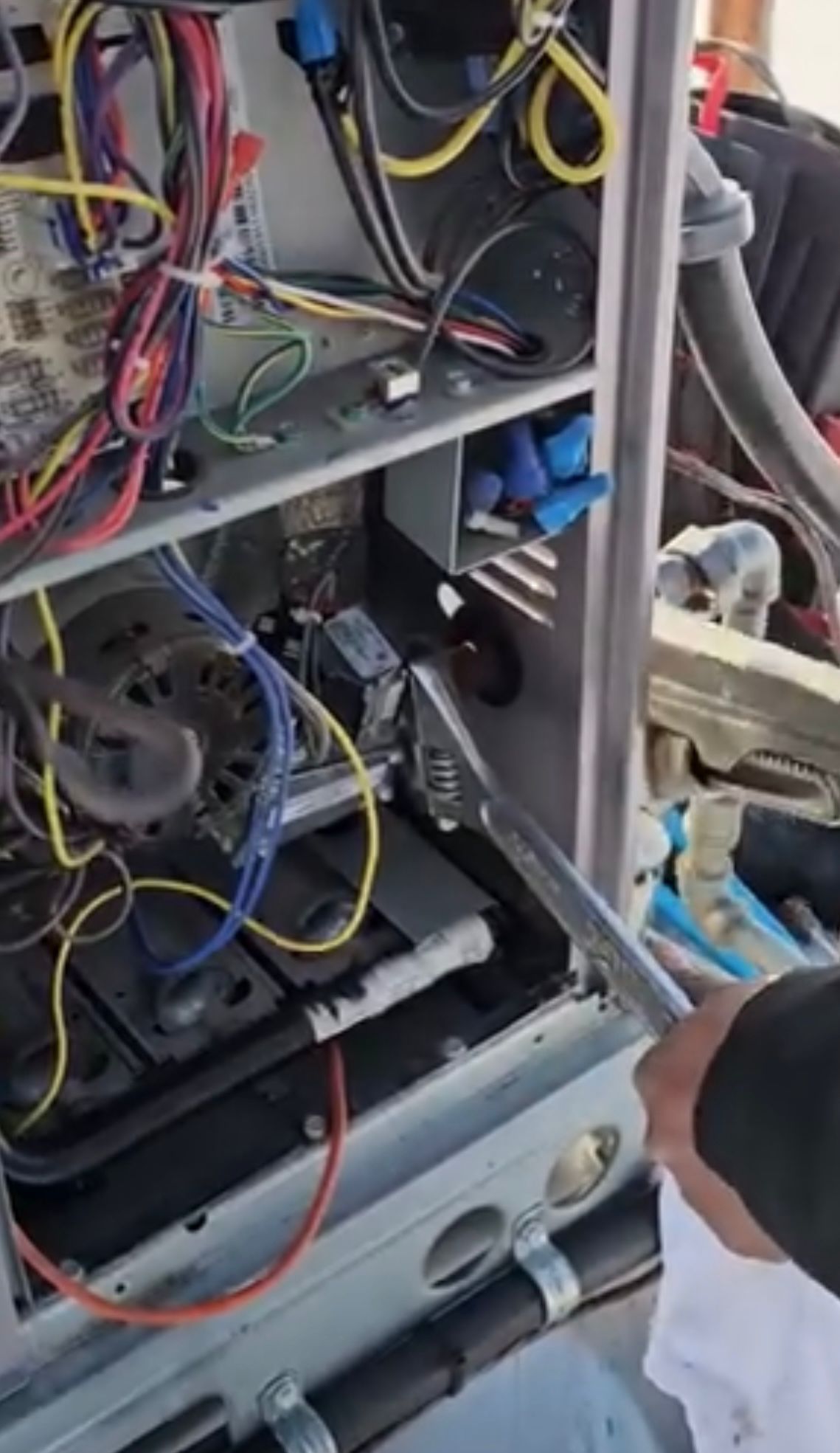 HVAC technician working on internal wiring and components of a commercial unit in Ajax