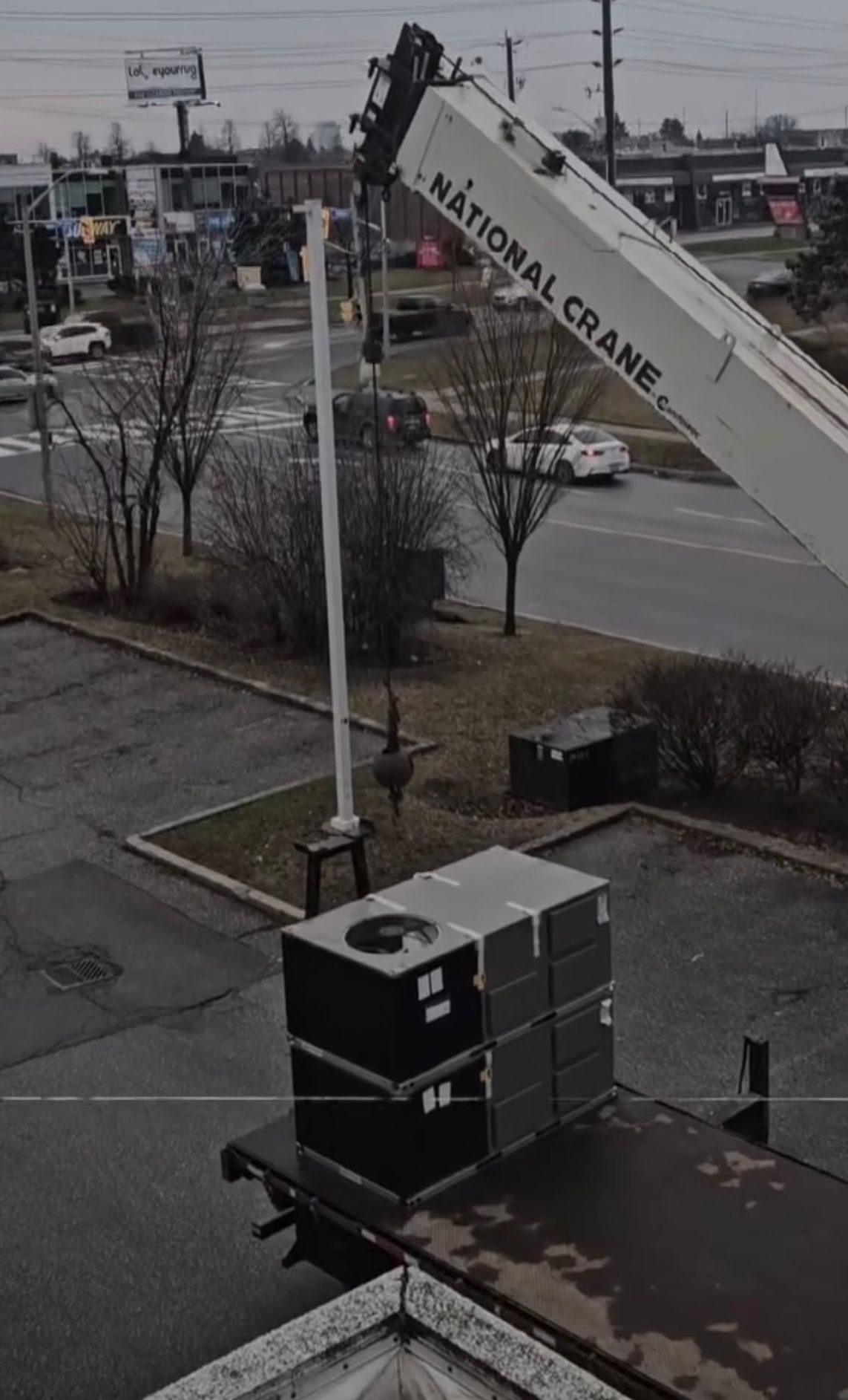 National Crane lifting a commercial HVAC rooftop unit at a Toronto business location