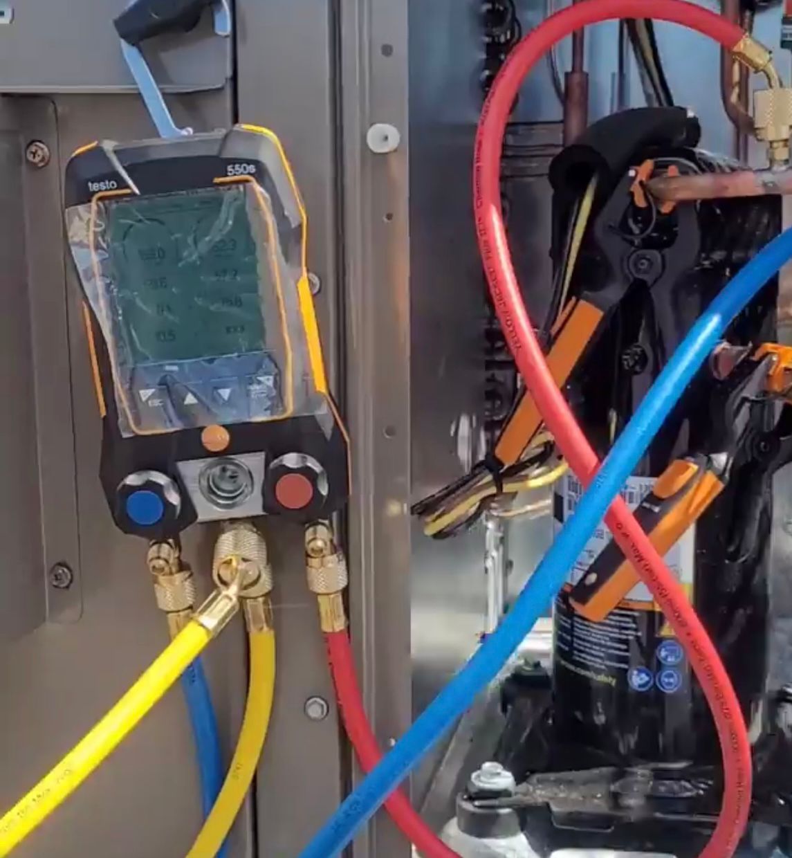 Testo digital manifold gauges connected to HVAC equipment during diagnostics at a Markham job site